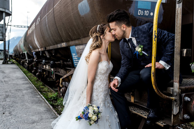 Brautpaar bei Eisenbahnwagen am Kuessen